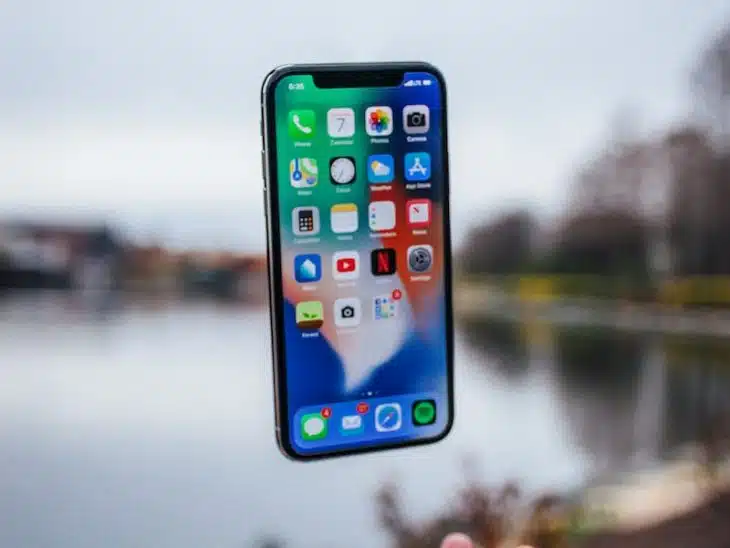 silver iPhone X floating over open palm