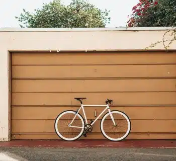 white bike leaning on brown roller shutter