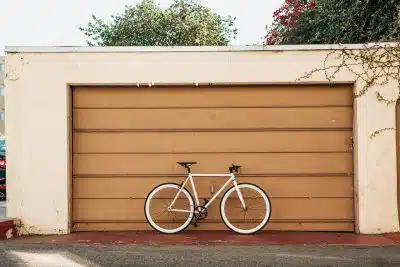 white bike leaning on brown roller shutter